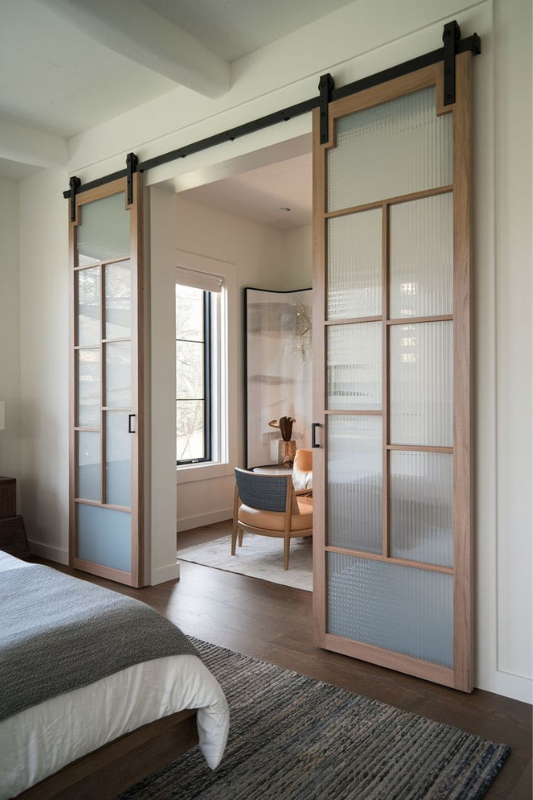 Stylish wood and glass sliding doors creating a private room divider in a studio apartment, perfect for maximizing small space privacy in 2025








