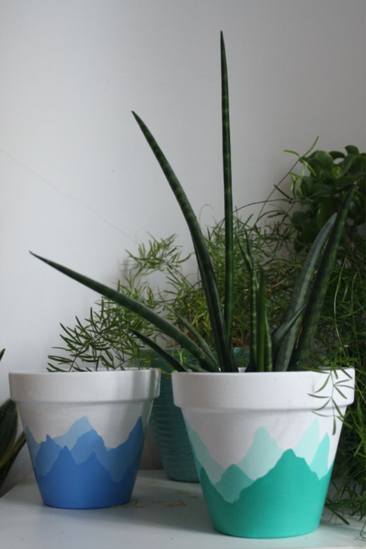 Creative hand-painted terracotta pots with layered mountain silhouette designs in calming blue and green shades. Perfect for nature lovers, these outdoor and indoor planters bring peaceful, minimalist landscape art to your plant decor.