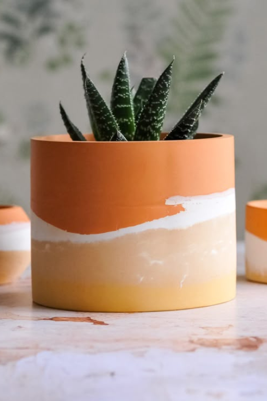 Bright and modern hand-painted succulent planter pot featuring a bold orange, white, and yellow colorblock design with organic brushstroke transitions. Perfect for small houseplants, this colorful ceramic pot adds a vibrant, artistic touch to boho and contemporary home decor. Ideal for coffee tables, windowsills, or room accents.