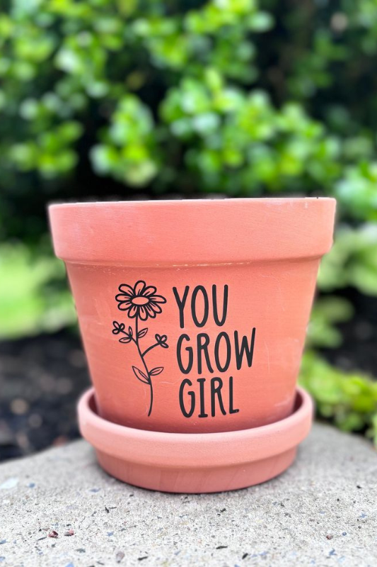 Empowering terracotta flower pot with hand-lettered “You Grow Girl” text and a simple flower sketch. Perfect for gifting to plant lovers or decorating outdoor patios with a motivational gardening quote and rustic charm.