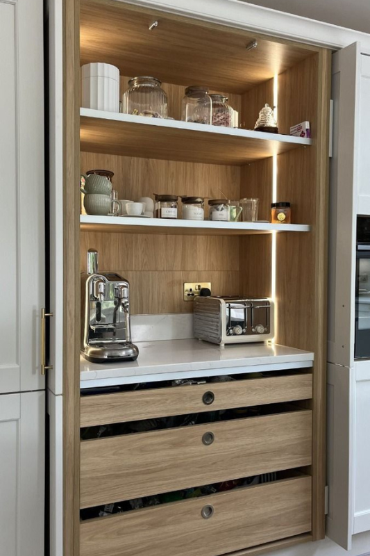 Built-in coffee and appliance station with open shelving, light wood finish, and integrated lighting for a stylish kitchen setup.