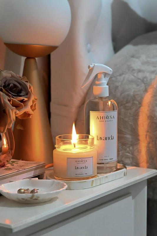 Lavender-scented candle and matching room spray on a cozy bedroom nightstand, styled with soft lighting, faux roses, and neutral bedding — perfect for relaxing bedroom decor ideas, cozy nightstand styling, and lavender aromatherapy inspiration. 