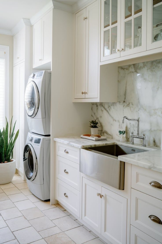 Space-saving laundry closet with stacked washer and dryer, open shelving, vertical towel drying rack, and natural woven hampers.