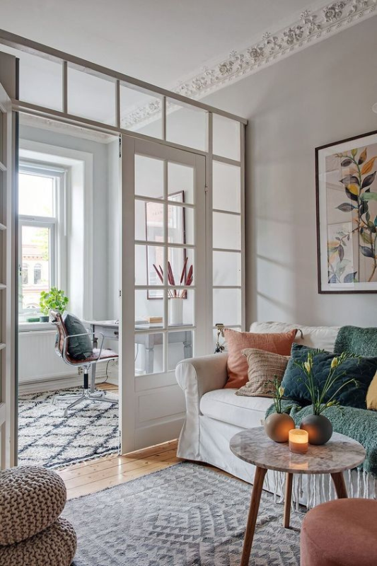 Minimalist bedroom closet with a warm wood finish, sliding door, hanging clothes, and neutral woven storage.